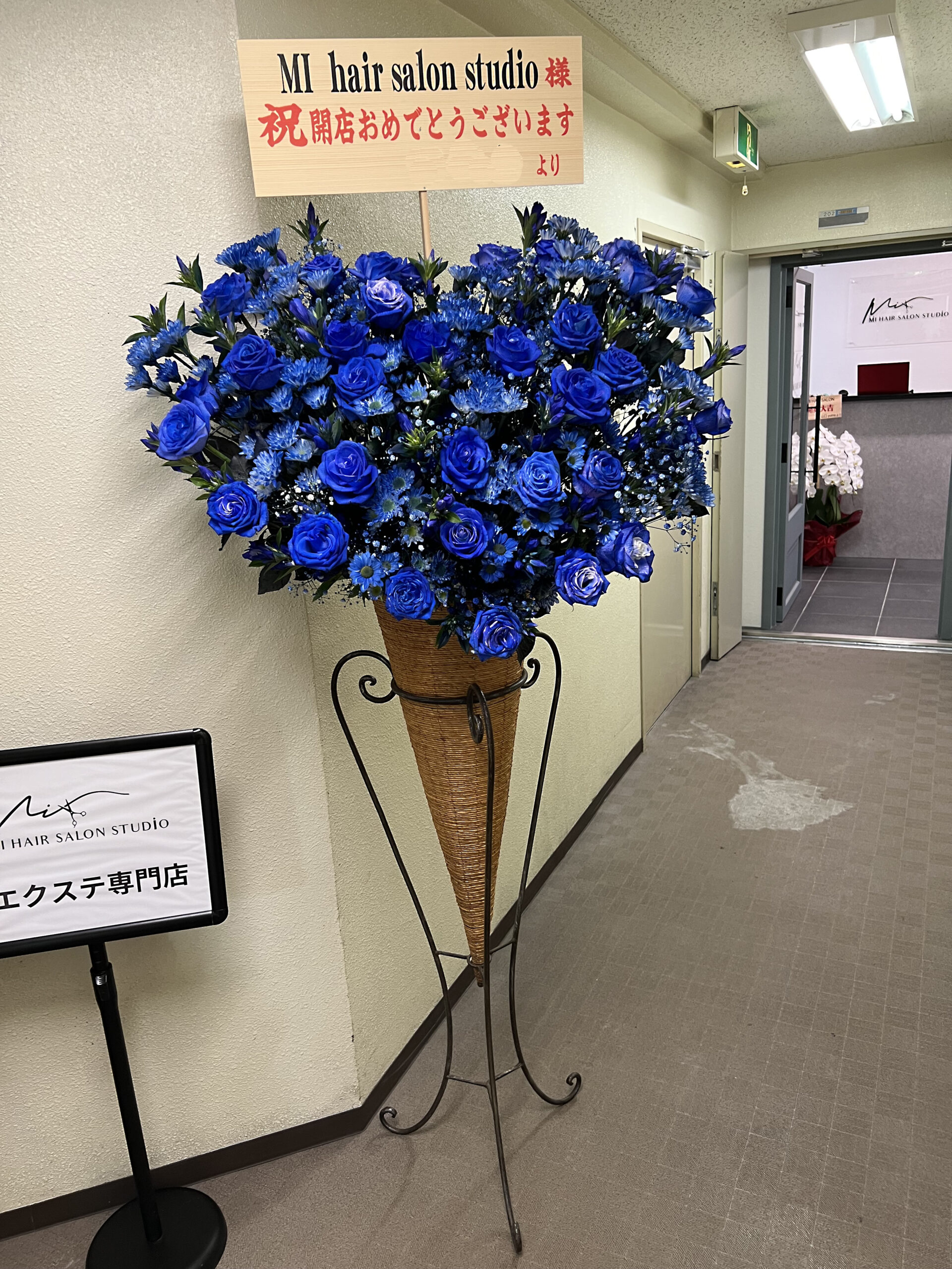 池袋のビューティーサロン開店祝いにお届けした青いスタンド花