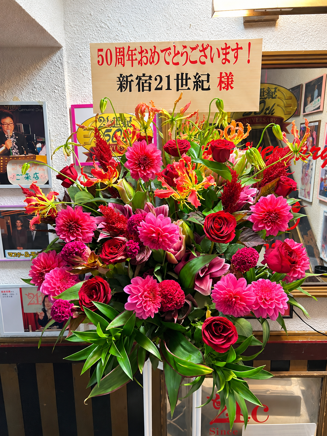 2026年10月26日、新宿区西新宿のライブハウス新宿21世紀の50周年祝いにお届けした赤とピンクの華やかなスタンド花｜むつみ花店